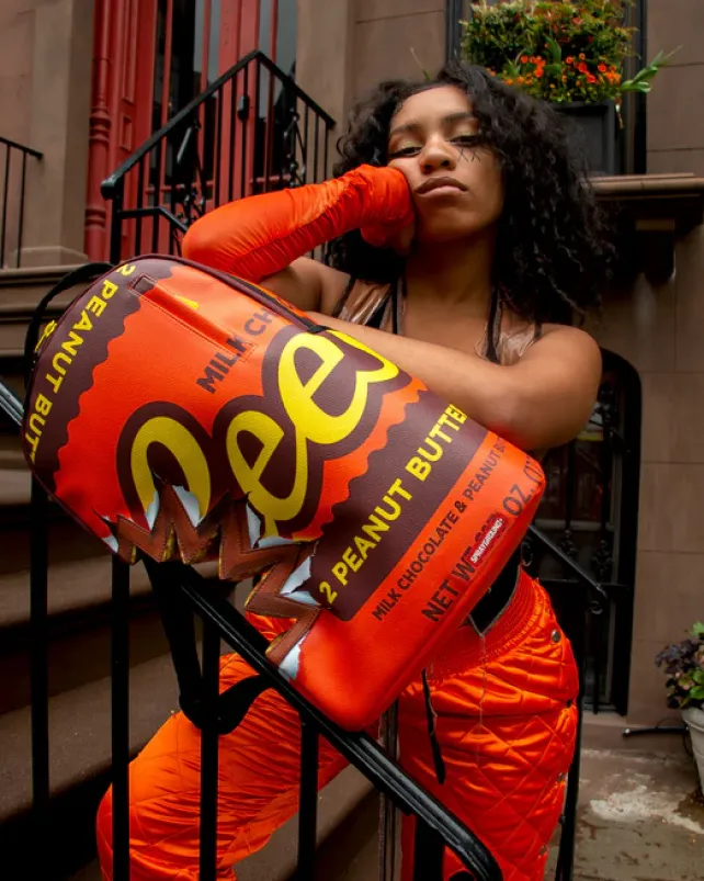 BACKPACKS>SPRAYGROUND REESE'S SHARK BITE BACKPACK (DLXV)